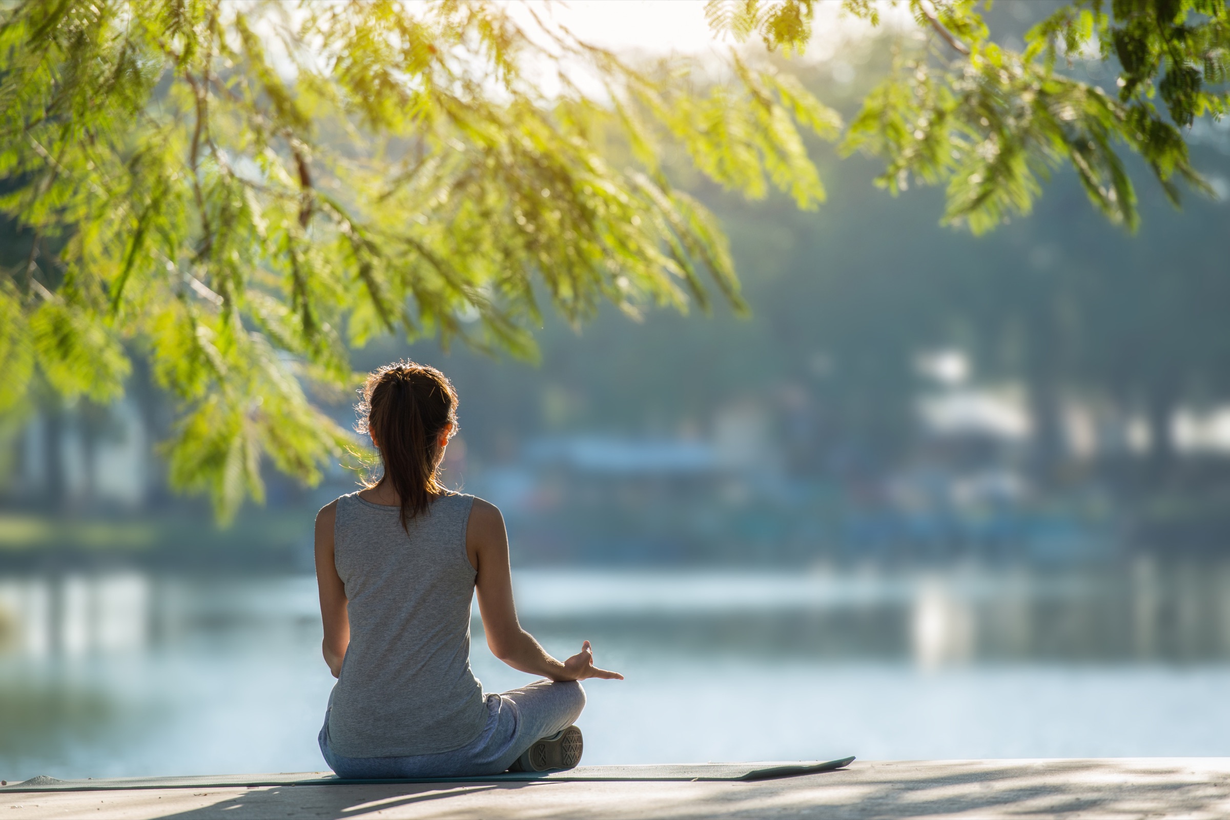 A person meditating peacefully by a calm lake